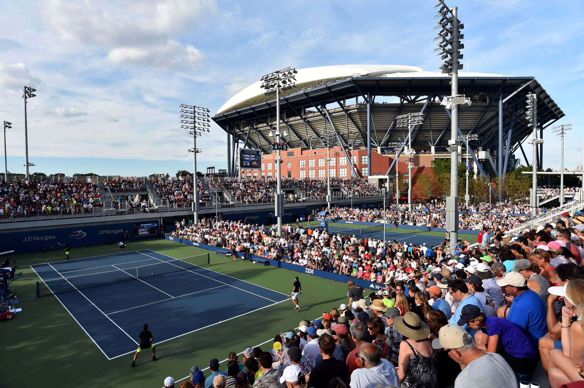 A crowded US Open court with Arthur Ashe Stadium behind it